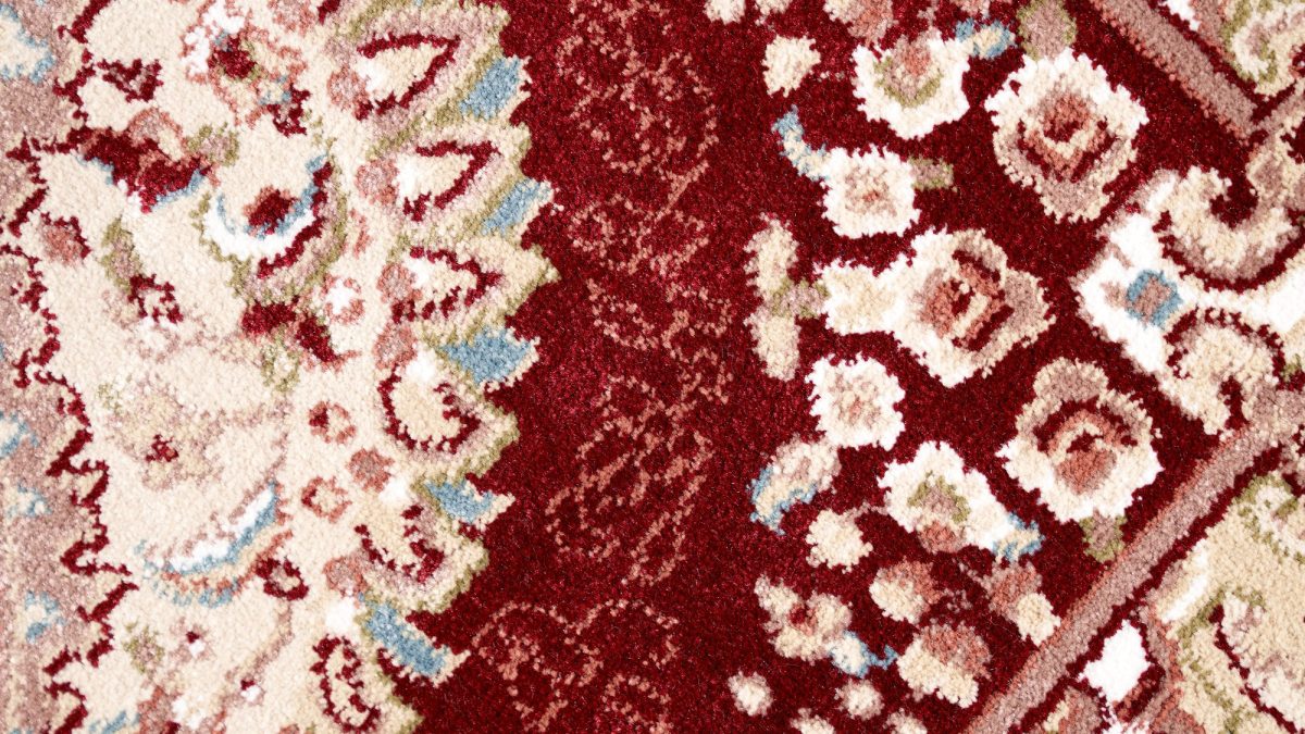 Extreme close-up of woven rug pile showing knotted fibers and a dense patterned weave